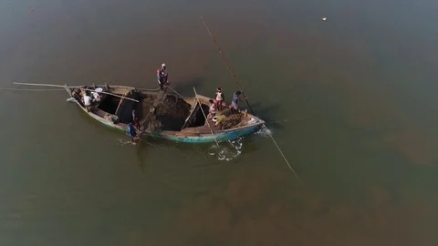 Indians on the boat manually take out the sand from the bottom of river. Aerial. Stock-Footage 85434532