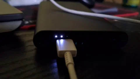 The indicator light of a power bank lights up white when it is being charged Stock Footage 257174131