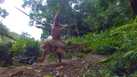 Indigenous hunter with a spear running through the amazon rainforest slow motion Видео 113594783