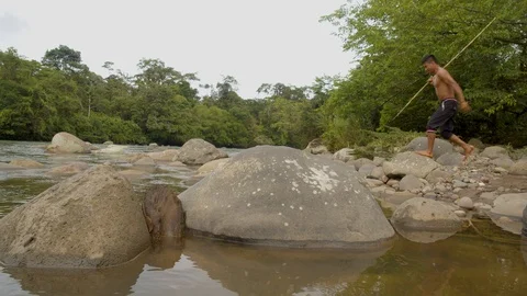 Indigenous hunter trying to fish with a spear by the river in the amazon Vidéo 113506655