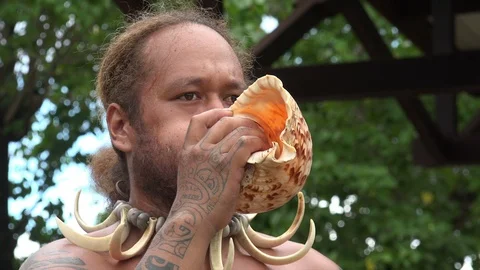 Indigenous man blows conch shell horn, Nuku Hiva, French Polynesia Stock Footage 109648858