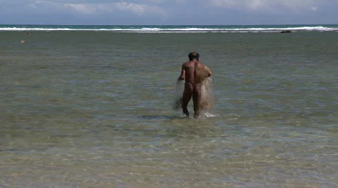 Indigenous man with a cast net is walking out in to the water for fishing Video stock 605143