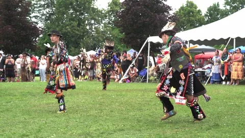Indigenous man dancing outdoor on grass at a pow wow event Stock Footage 246399486