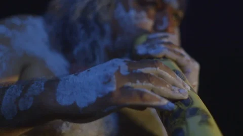 An indigenous man playing a didgeridoo Stock Footage 107221155