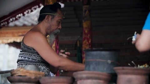 Indigenous man preparing for Bali Hindu ritual Melukat Mebayuh Stock Footage 140296057