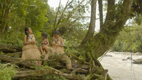 Indigenous man swinging on a rope while his family works in ecuador Stock Footage 113512934
