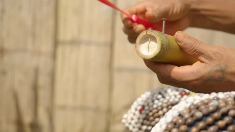 Indigenous man is trying to build a flying device by attaching a wing to bamboo Stock Footage 113179943