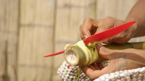 Indigenous man is trying to build a flying device by attaching wings to a bamboo Stock Footage 113180136