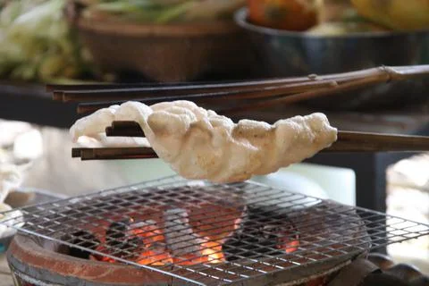 A indigenous rice cracker grilling over fire from stove. Foto stock