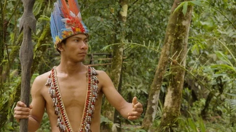 Indigenous warrior showing the viewer the amazon rainforest in ecuador Видео 113566292