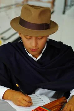 Indigenous young man writing notes to music with rondador, concept of Stock-Fotos