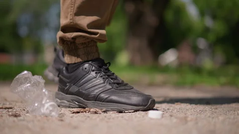 Individual Crushes Plastic On Pathway Intentionally, Scene Depicts Individual Stock Footage 330898282