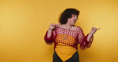 Individual dancing joyfully in front of a vibrant yellow background showcas.. Stock Footage 313950395