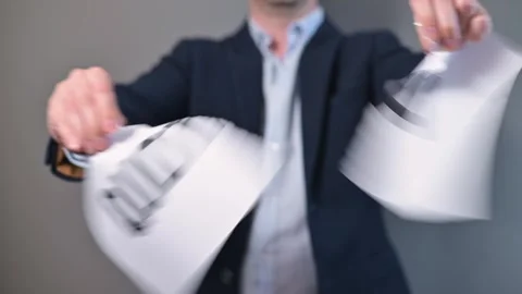An individual is engaged in an activity where they tear a paper marked with the Stock-Footage 338299596