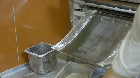 An Individual Engaging in Automated Dough Processing for Baking Purposes Stock Footage 258260619