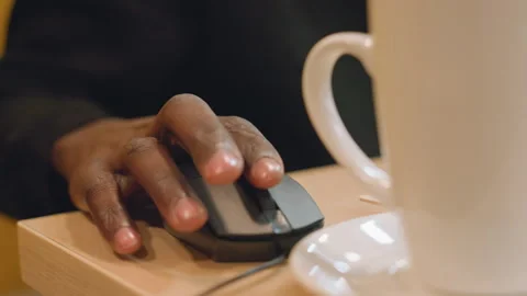 Individual engaging with laptop and mouse on wooden desk. Closeup shot of Stock Footage 333182785