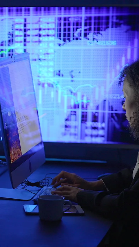 An Individual with Focus and Concentration Analyzing Data on a Computer Stock Footage 295443518