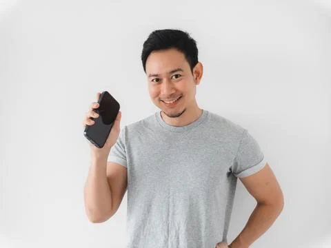 Individual with grey tshirt demonstrating device with bright smile Stock-Fotos