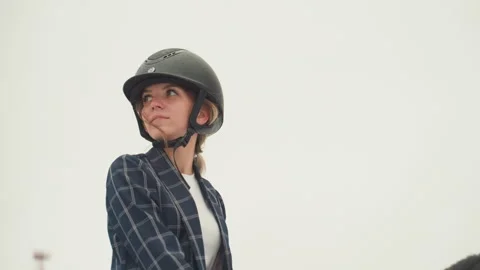 Individual in helmet engaged in equestrian training session. Closeup of woman in Stock Footage 335402458