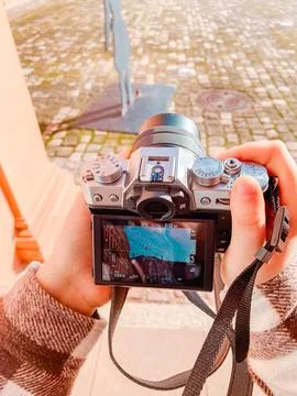 Individual holding a digital camera, capturing an artistic sculpture in an Stock Photos