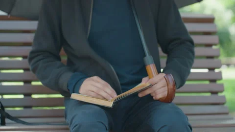 Individual jotting notes outside, Person focused on writing in park setting, Man Stock Footage 331070917