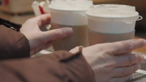 Individual purchasing beverage and small gift quickly in cafe setting. Person 스톡 동영상 346223602