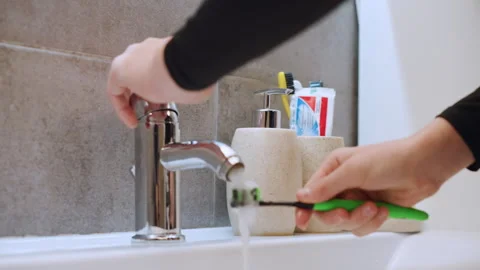Individual setting up toothbrush and toothpaste for morning hygiene routine 스톡 동영상 332275334