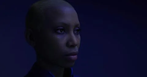 Individual with shaved head in contemplative pose under blue lighting Illustrazione stock