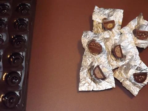 Individual silver wrapped chocolates with different fillings in a box Stock Photos
