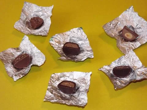 Individual silver wrapped chocolates with different fillings in a box Stock Photos