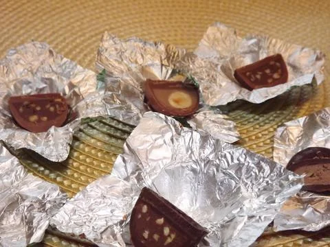 Individual silver wrapped chocolates with different fillings in a box Stock Photos