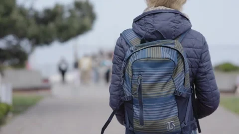 Individual Strolling Through a Cityscape while Carrying a Backpack on their Stock Footage 304729061