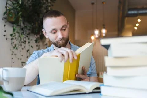 Individual studying with books in a cafe while engaging in online learning .. Foto stock