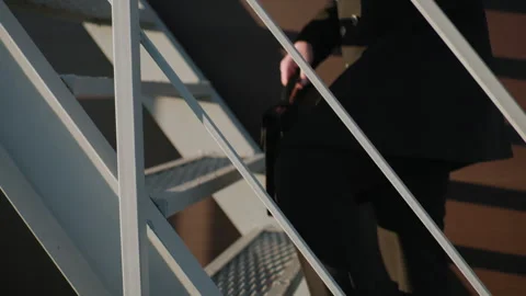 Individual Switching Briefcase from Left Hand to Right Hand While Climbing Stock Footage 295383476