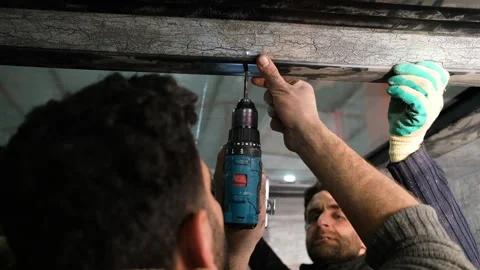 Individual using drill to install ceiling feature Stock Footage 327592622