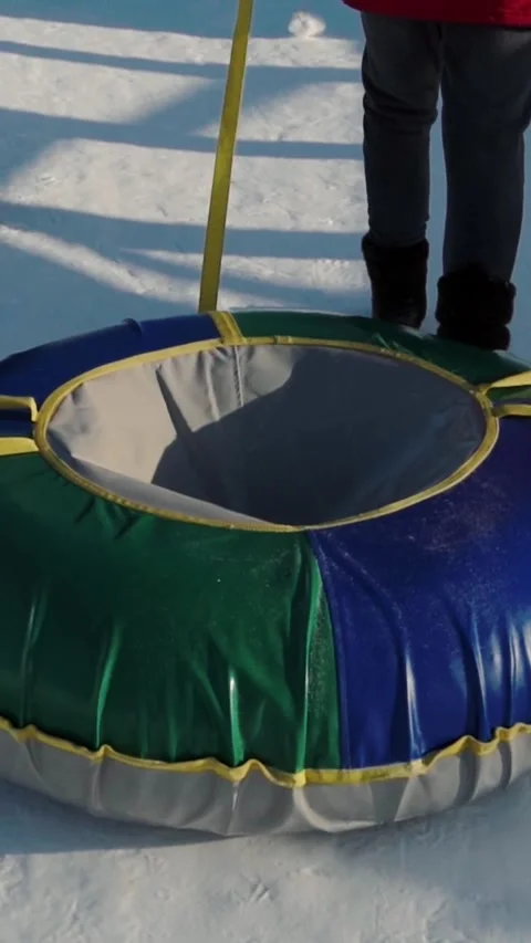 Individual zooming down snow covered slope on inflatable tube facing sledding Stock Footage 346640005
