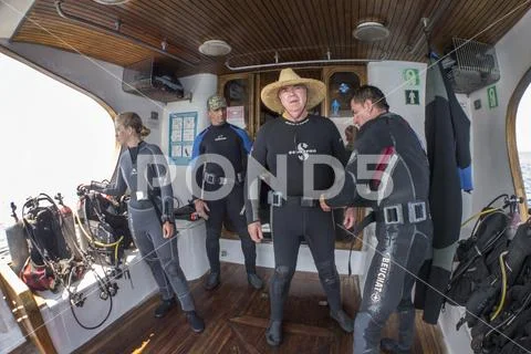 , individuals getting ready to dive near Gordon Rocks Stock Photos