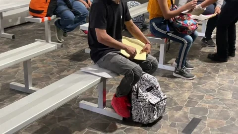 Individuals preparing documentation for inspection at migrant processing center Stock Footage 150426136