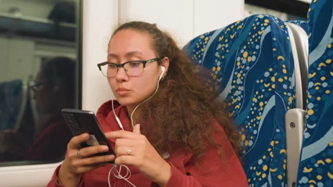 Individuals on train interacting with electronic devices and media. Multiple 動画素材 334630307