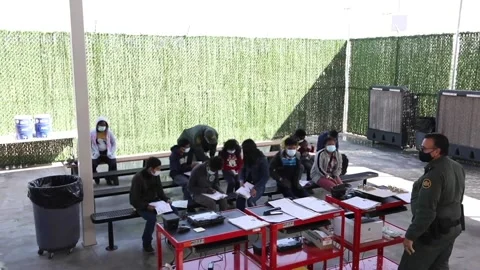 Individuals wait with paperwork for processing at El Paso processing center Stock Footage 151251615