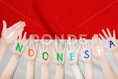 Indonesia inscription on the children's hands against the background of a wav Stock Photos