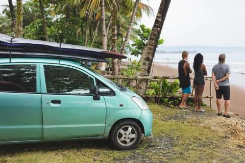Indonesia, Java, friends standing at the coast next to car with surfboards Stock Photos