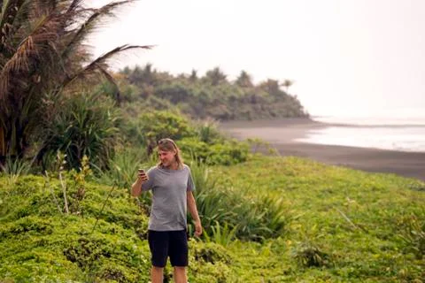 Indonesia, Java, man using cell phone at the coast Stock Photos