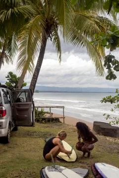Indonesia, Java, two women preparing surfboard at the coast Stock Photos