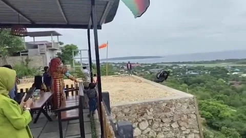 Indonesia: Paraglider crashes while trying to launch from cafe across rav... 動画素材 326027406