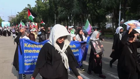Indonesia: Protesters march toward US Embassy in Jakarta over US-Israel a... Stock Footage 330435213
