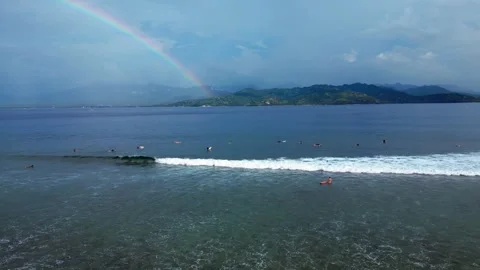Indonesia surfers waiting for waves under rainbow. Nice aerial view drone Stock Footage 344620672