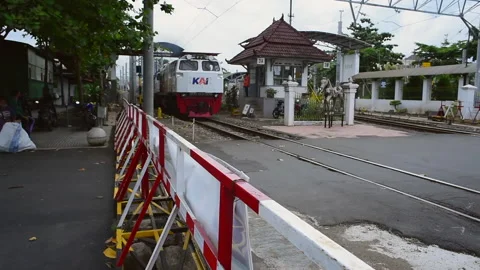 Indonesia train or Kereta Api Indonesia crossing road with horn and alarm sounds Stock Footage 151024683