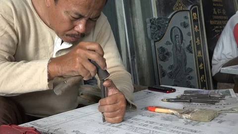 Indonesian artisan uses chisel to create grave headstone, Chinatown Surabaya Video stock 78428005