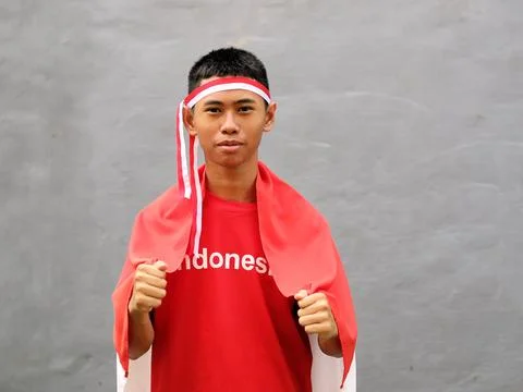 Indonesian boy with red and white headband holding Indonesian flag Stock-Fotos
